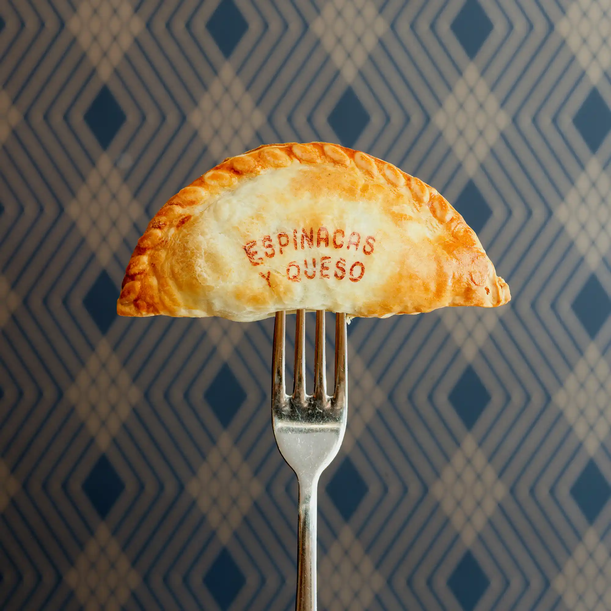 Empanada argentina pinchada con tenedor, calentada por expertos como recién hechas.